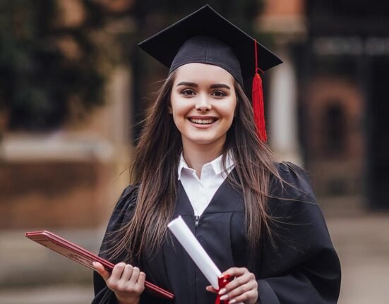 A girl standing with her degree