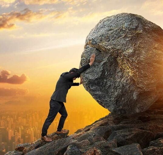 a man pushing a big stone